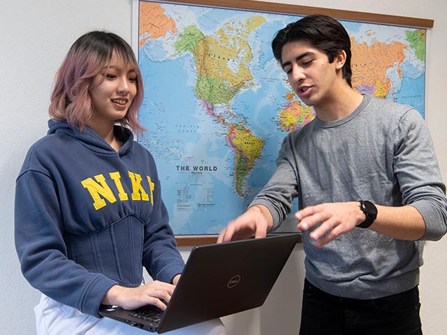 Female student on laptop with male lecturer