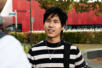 Male student talking to friend outside on campus