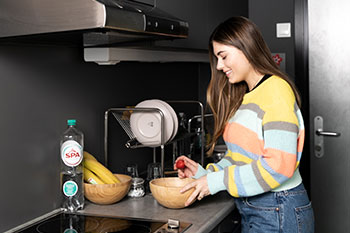 Female student using kitchen at accommodation