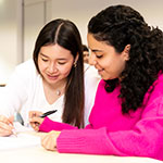 Two female students working in classroom