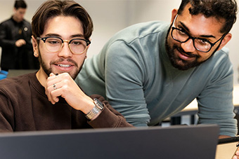 Two male students looking at laptop