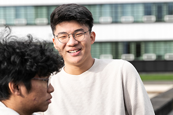 Male student with friend on campus.