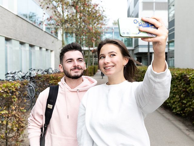 Two students taking a selfie on a mobile phone.