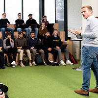 Lecturer talking to class of business students