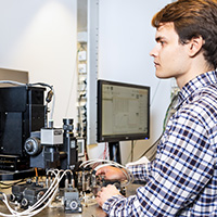 Student using computer monitor to view electrial components