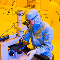 Lab technician using equipment in a bright yellow room